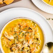 Bowl of chicken wild rice soup with shredded chicken, wild rice, carrots, and fresh thyme