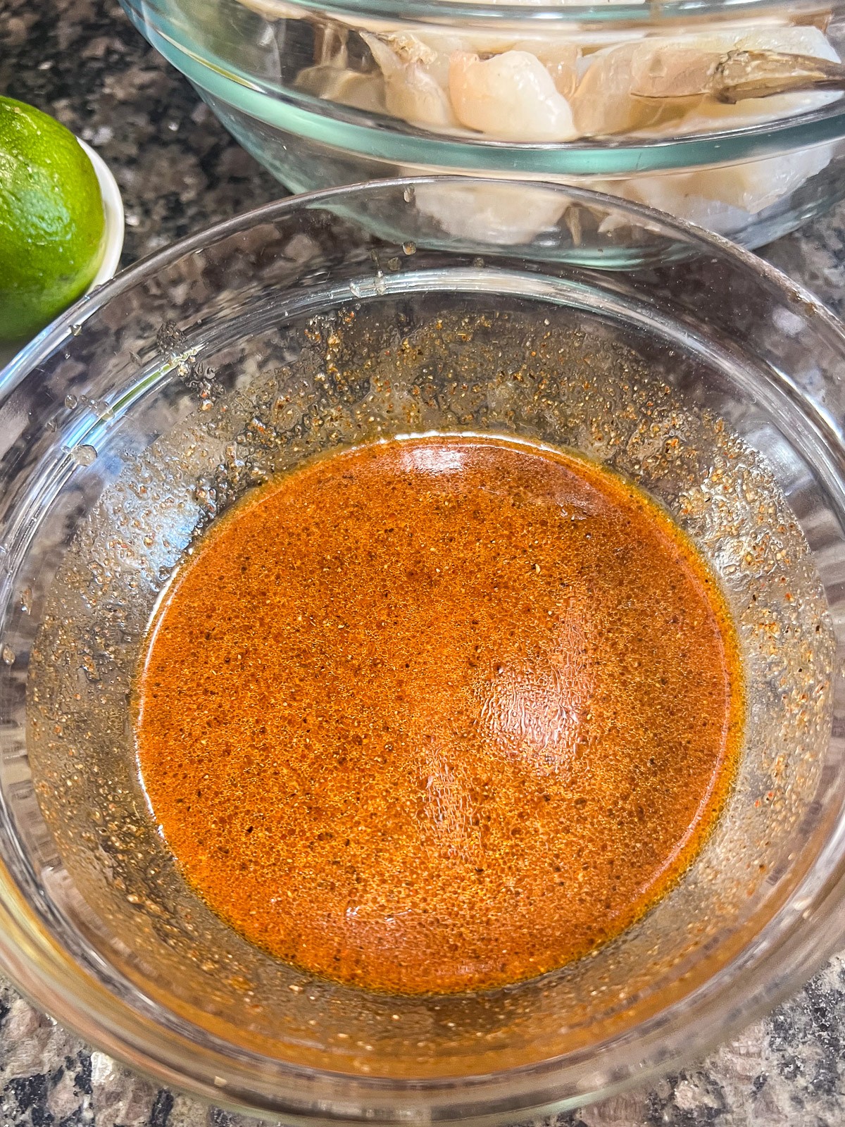 Chili lime shrimp marinade with chili powder, chipotle, cumin, garlic, and lime juice in a bowl