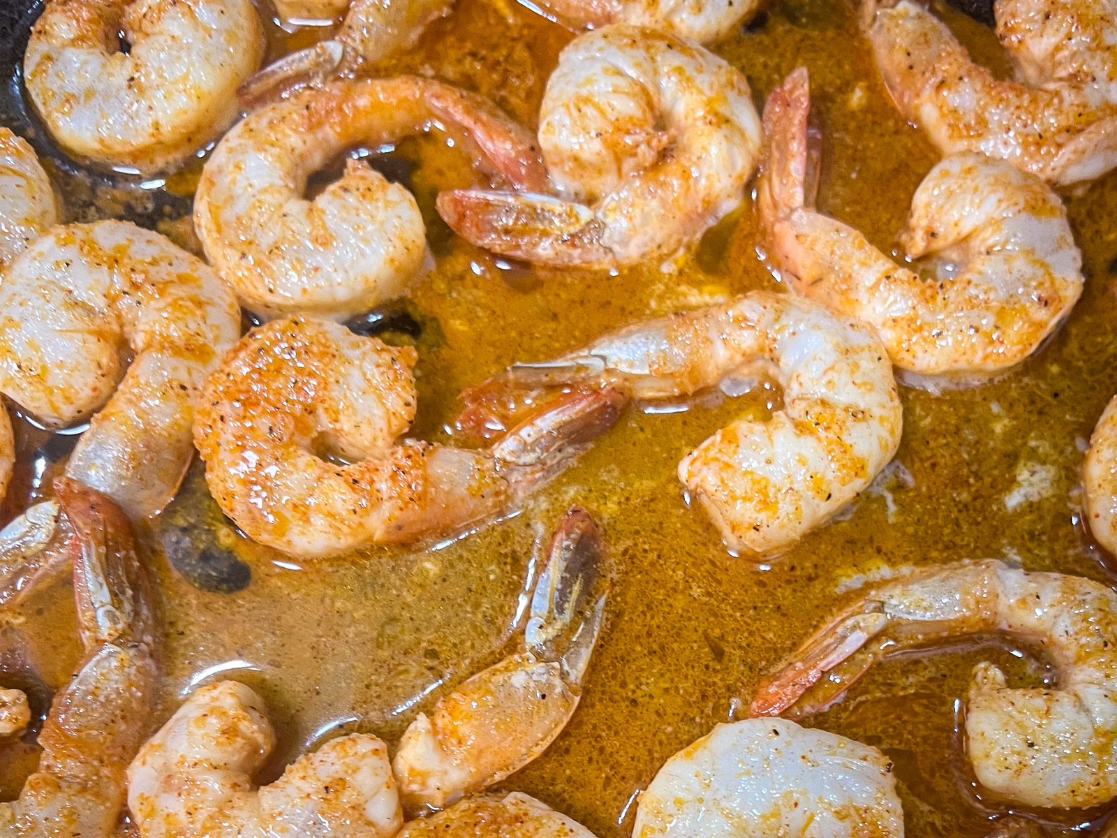 Chili lime shrimp searing in a hot cast iron skillet