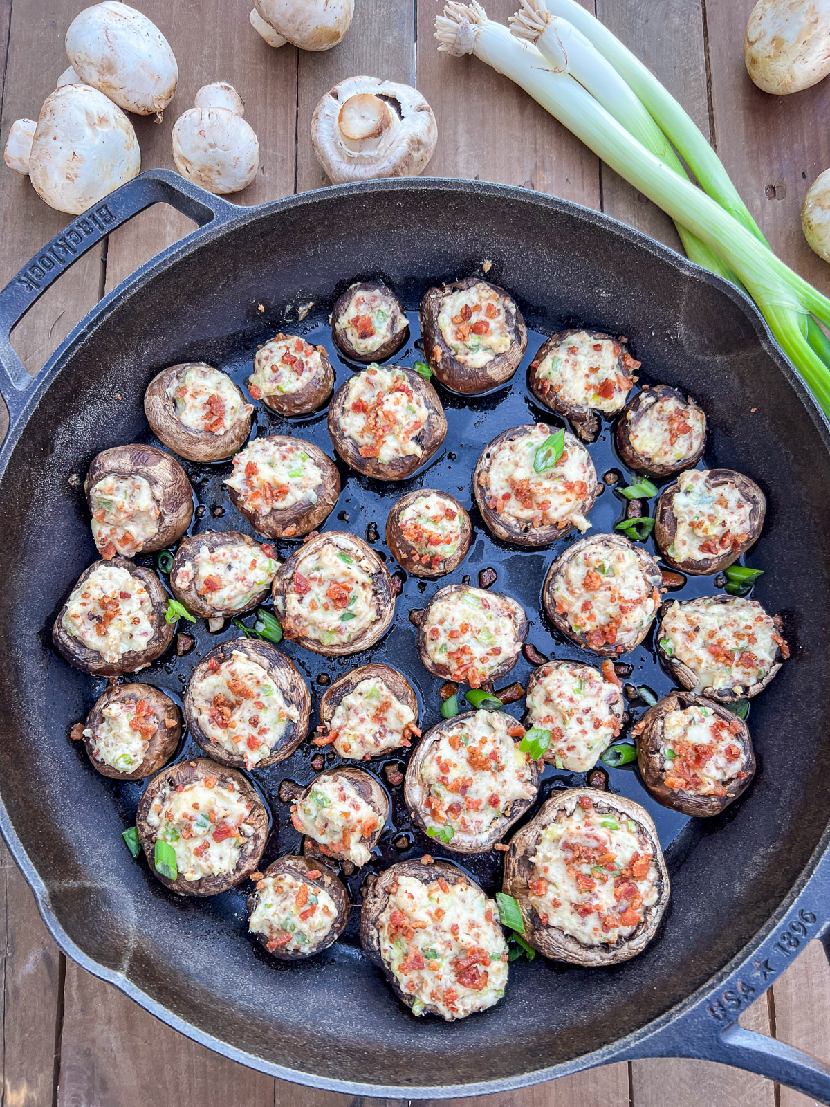 Dutch oven stuffed mushrooms with cream cheese, bacon, and green onions in a Lodge cast iron Dutch oven