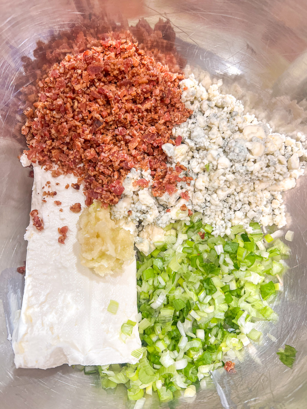 Mixing the cream cheese stuffed mushroom filling in a bowl.