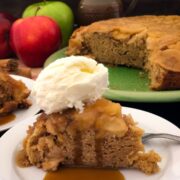 Slice of Dutch oven apple cake on a white plate with caramel sauce and ice cream