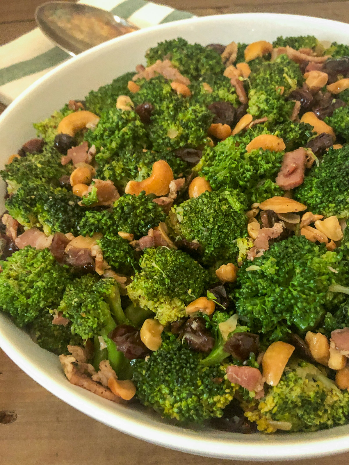 Close-up of cranberry broccoli salad with bacon and cashews served in a white bowl