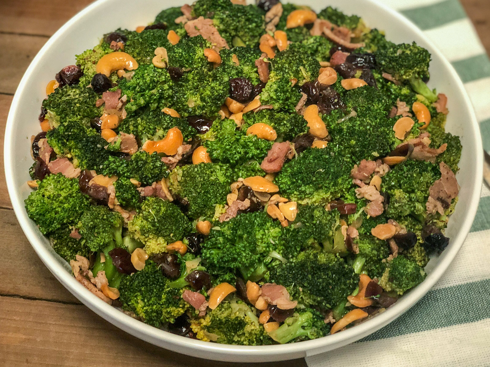 White bowl filled with cranberry broccoli salad with bacon and cashews