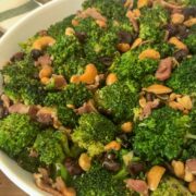 Close-up of cranberry broccoli salad with bacon and cashews served in a white bowl