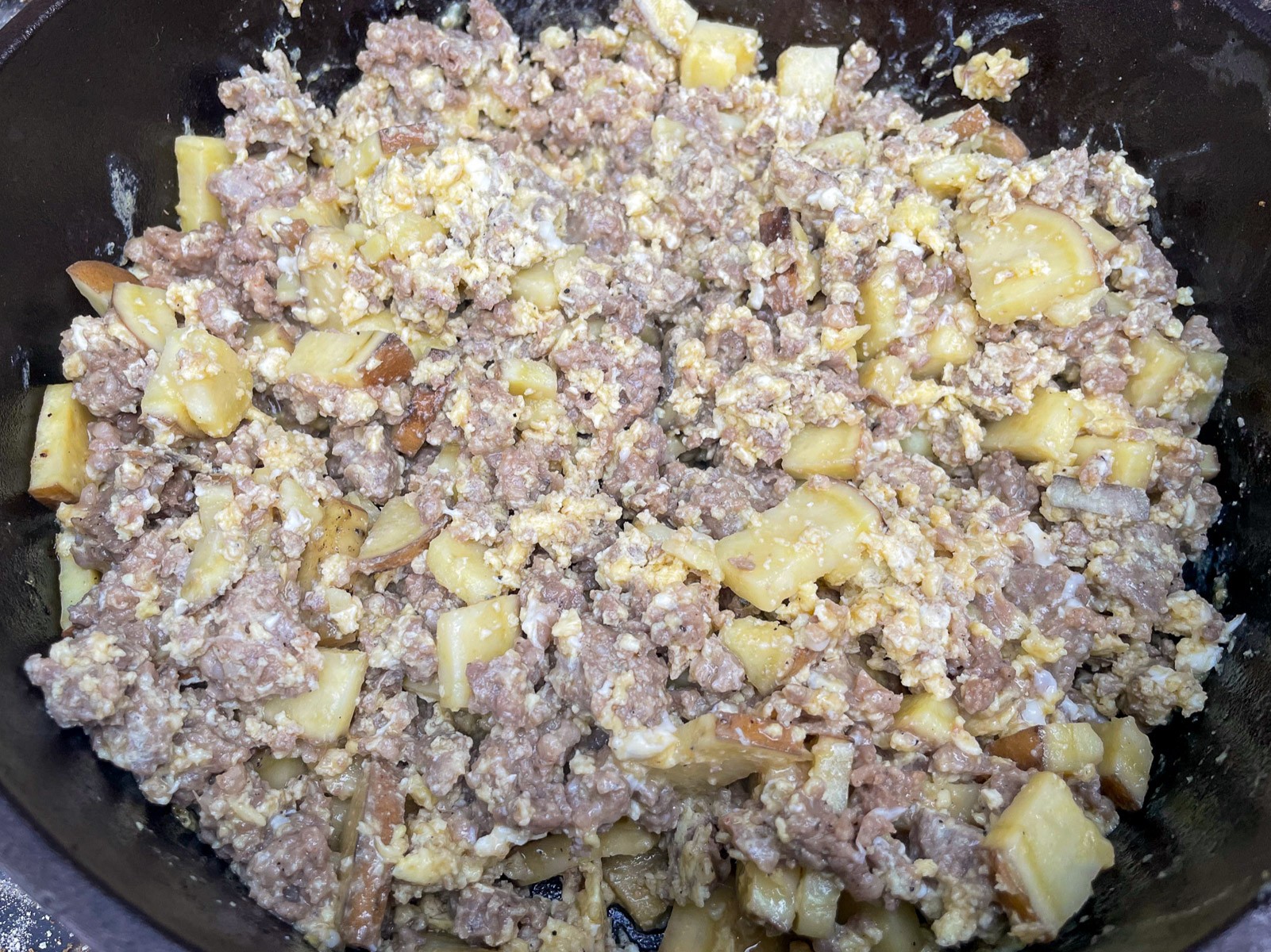 Mountain man breakfast cooking with eggs nearly set in the Dutch oven.