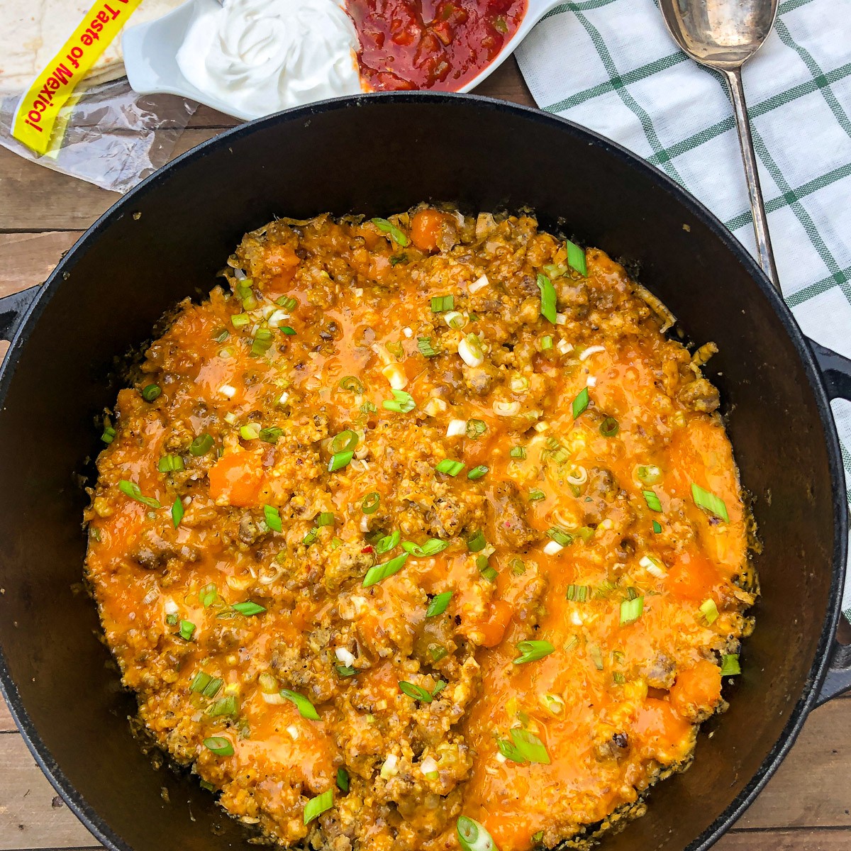Dutch oven mountain man breakfast casserole with melted cheese in a cast iron Dutch oven.