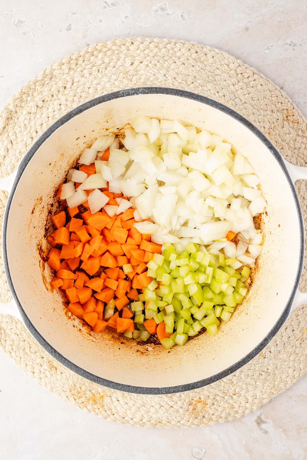 Onion, carrot, and celery cooking, then tomato paste and garlic added into the mixture.