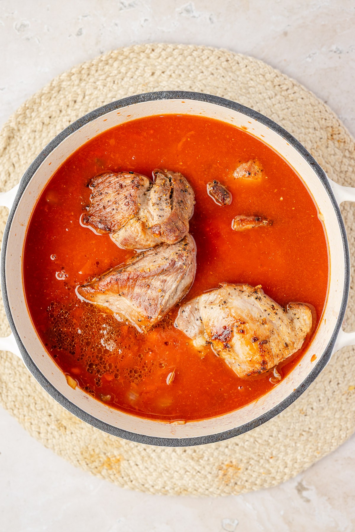 Pork added to the sauce to cook.