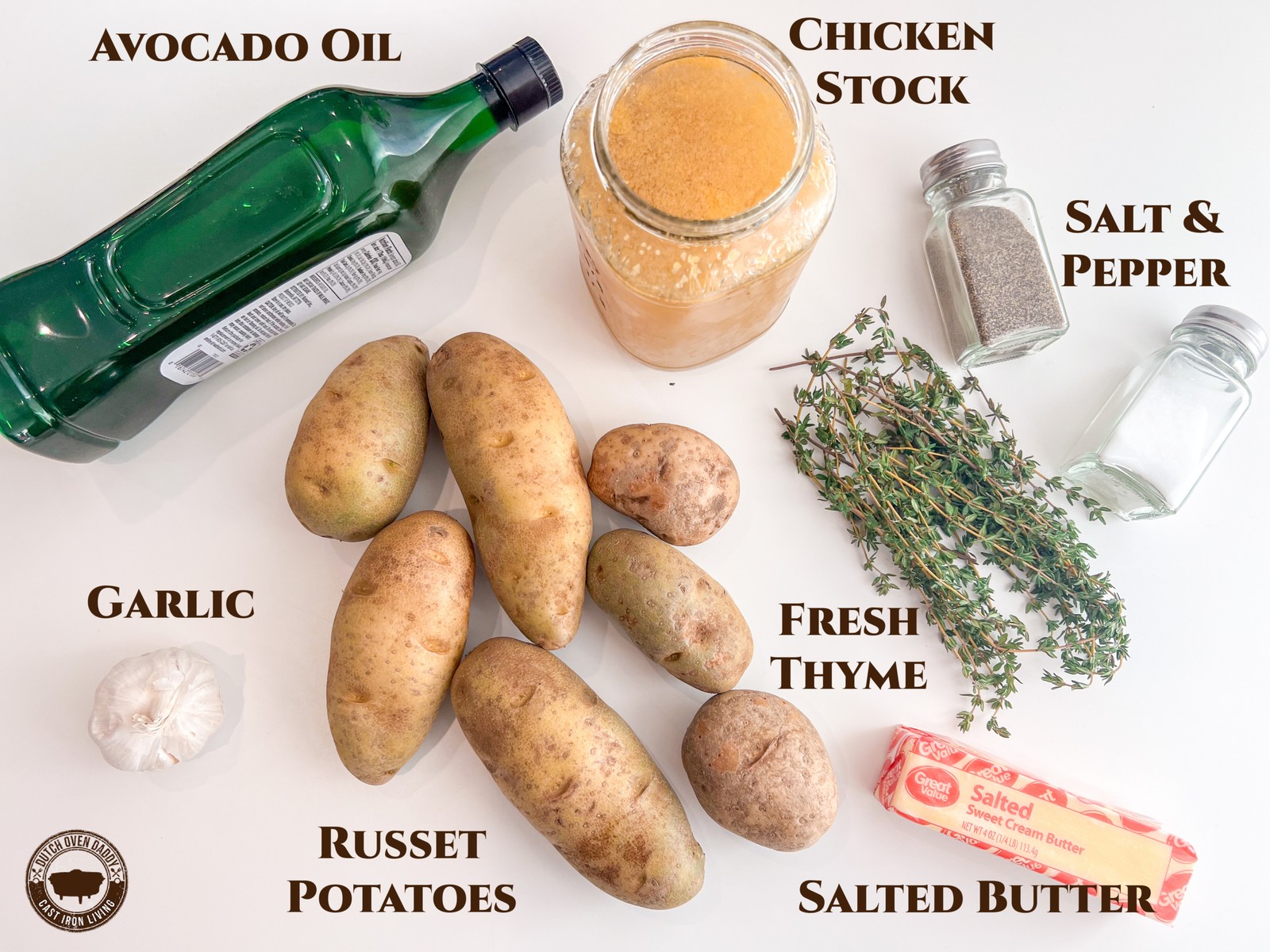 Ingredients to make fondant potatoes: avocado oil, homemade chicken stock, salt, pepper, fresh thyme, salted butter, russet potatoes, and fresh garlic.