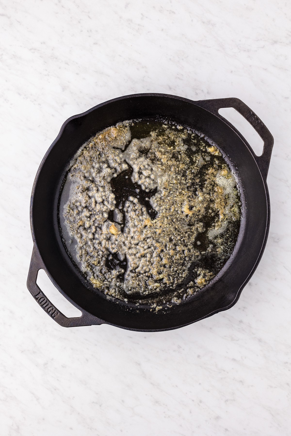 Butter browning with minced garlic in a cast iron skillet