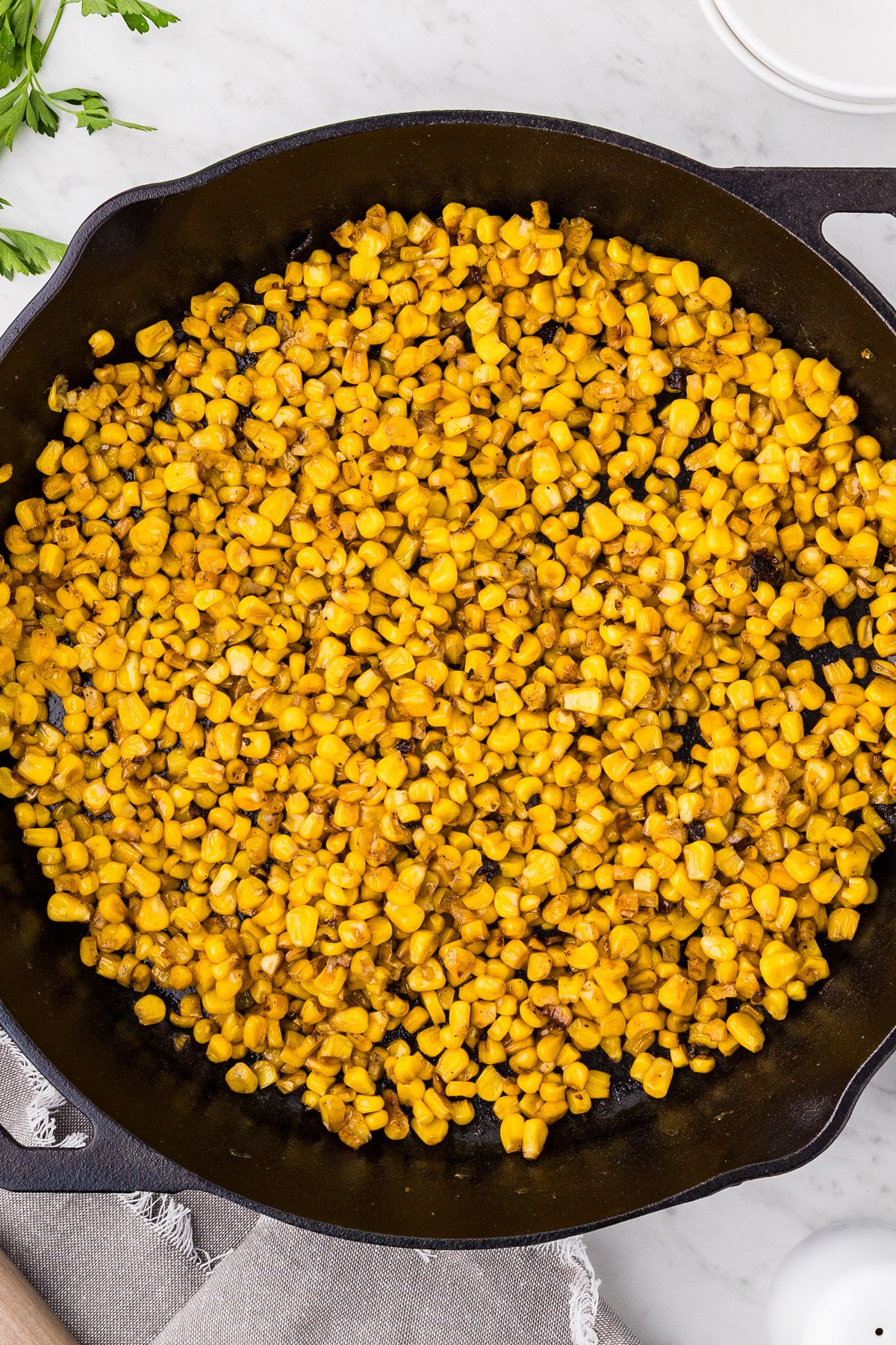 Finished garlic butter skillet corn in a cast iron skillet overhead view
