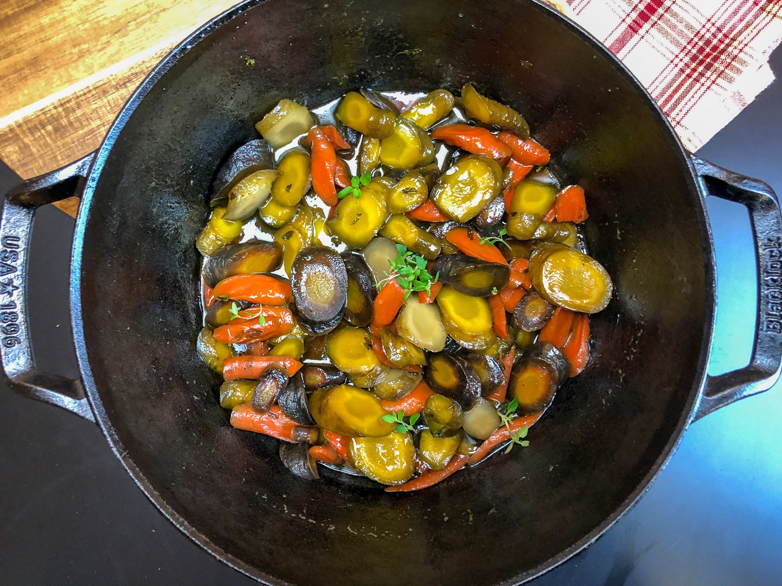 Honey glazed carrots in the Dutch oven with a thick, sticky glaze.