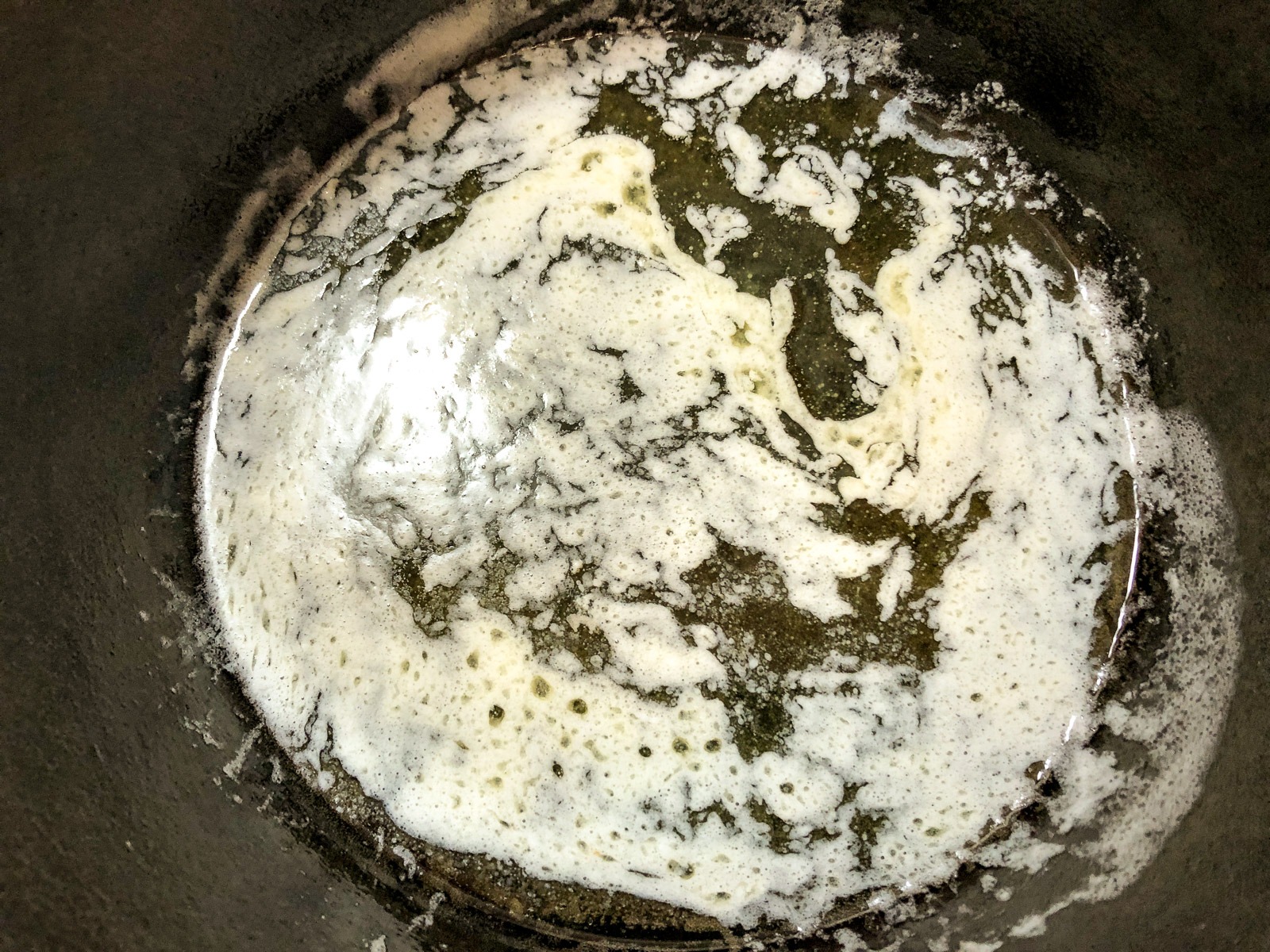 Butter melting in a cast iron Dutch oven before adding carrots.