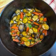 Honey glazed carrots in a Dutch oven with fresh thyme garnish