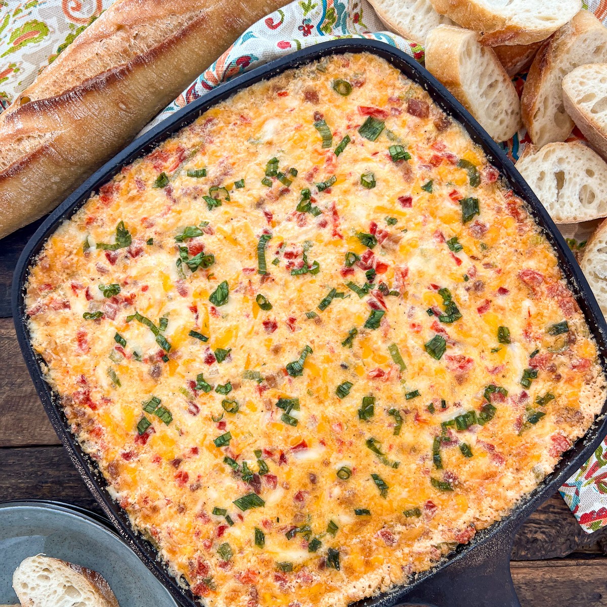 Hot pimento cheese dip baked in a cast iron skillet with golden bubbly top
