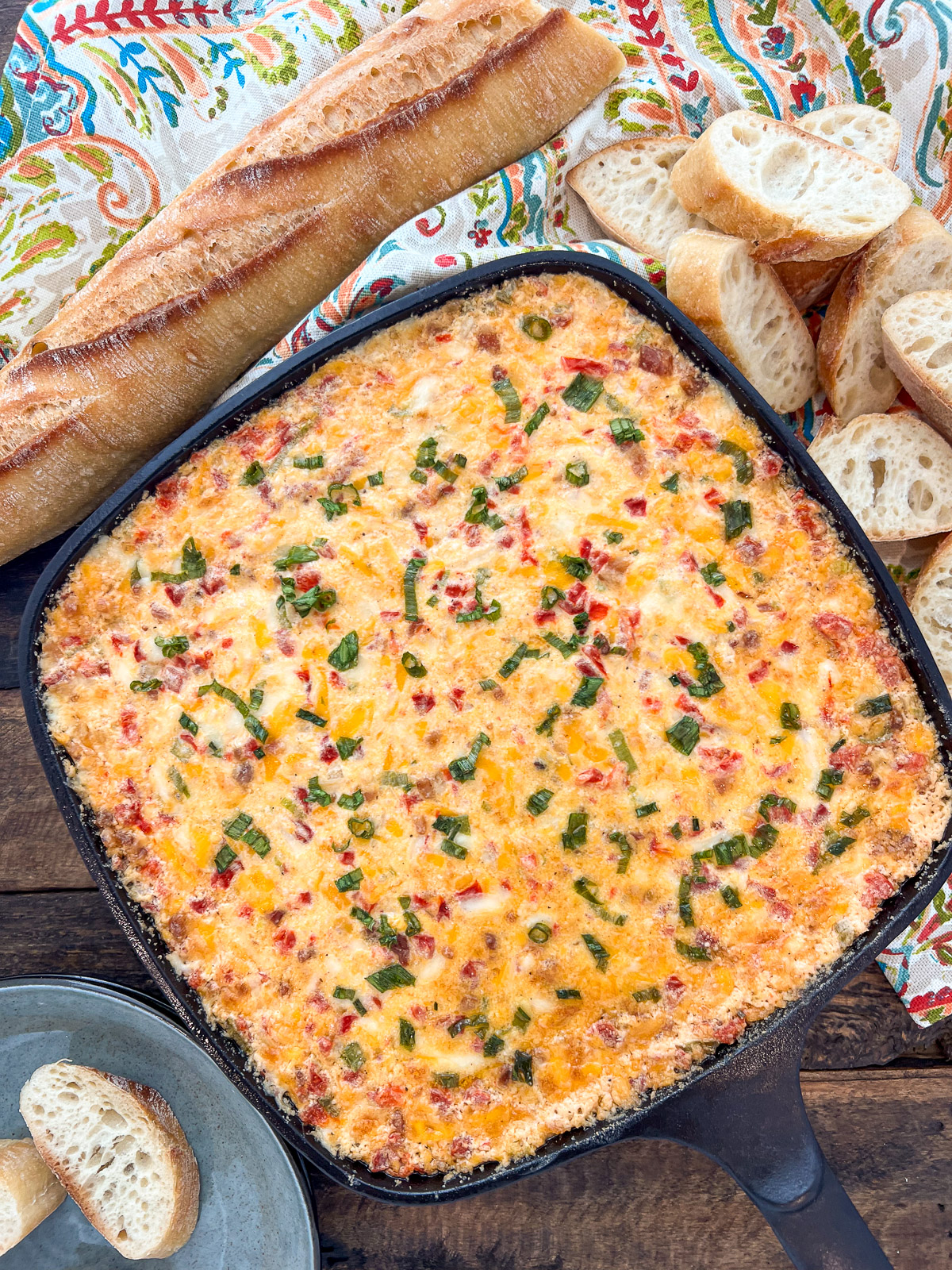 Hot pimento cheese dip fresh from the oven in a cast iron skillet topped with green onions