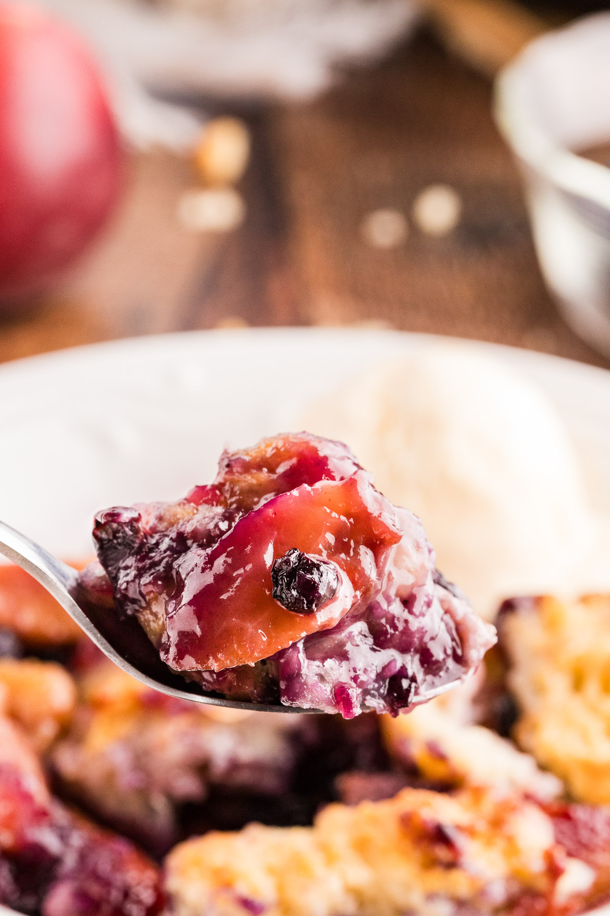 Spoonful of peach blueberry cobbler with jammy filling