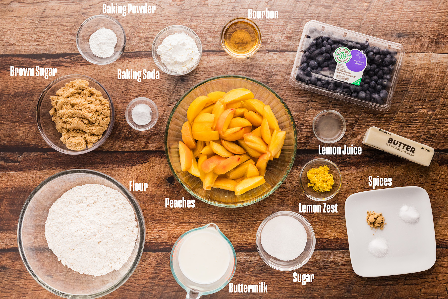Ingredients for peach blueberry cobbler laid out on a wooden surface