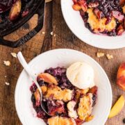 A serving of peach blueberry cobbler with vanilla ice cream