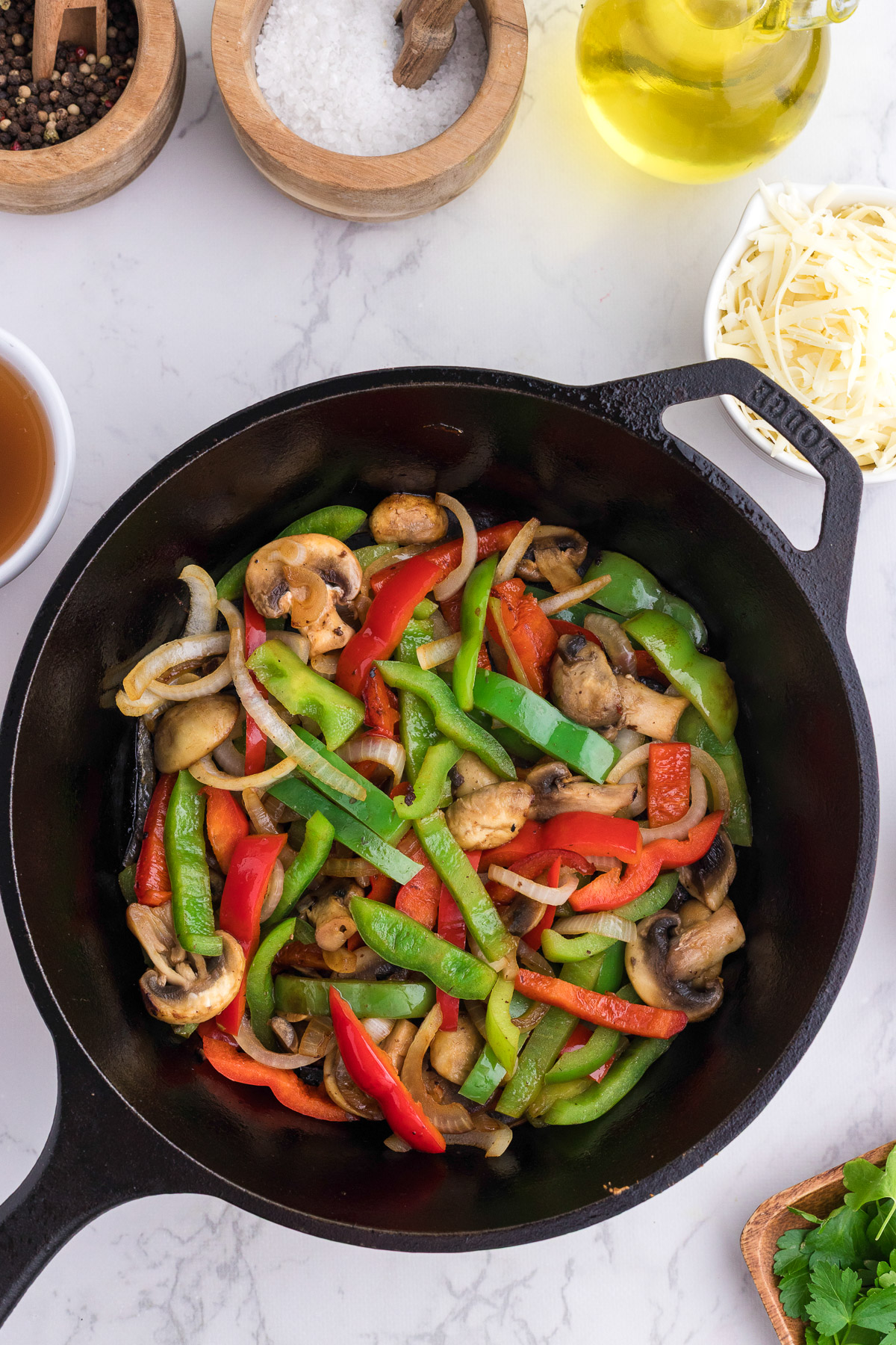 Sauteed peppers onions and mushrooms in a cast iron skillet