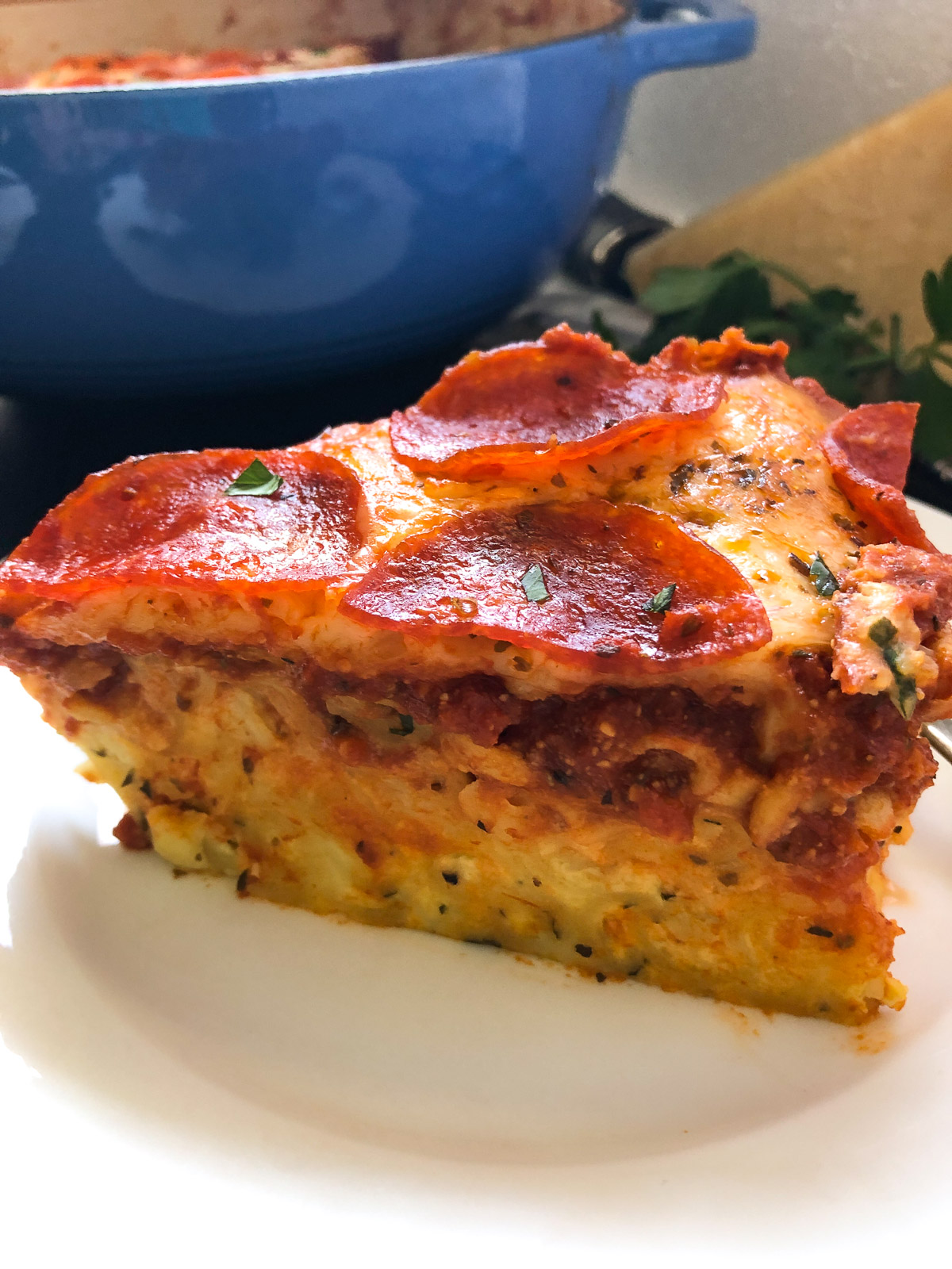 Close-up cross-section of pizza pasta bake showing the distinct layers of pasta, sauce, cheese, and pepperoni.
