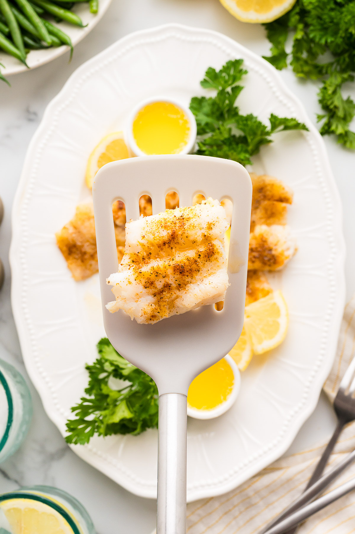 Close up of tender flaky poor mans lobster cod on spatula