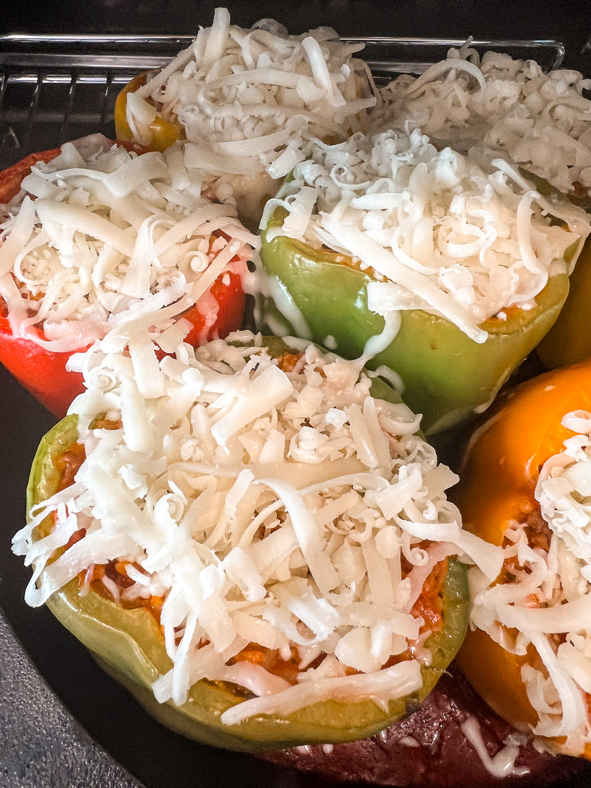 Aluminum foil covers the stuffed peppers in the cast iron skillet before going in the oven.