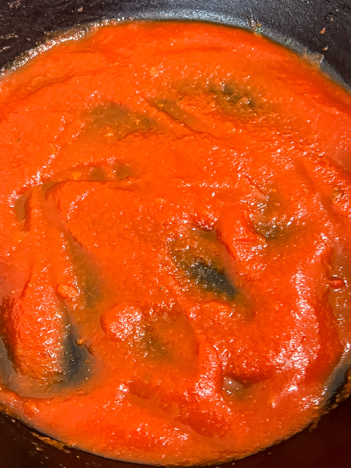 Pasta sauce being stirred into the meat and rice filling for stuffed peppers.