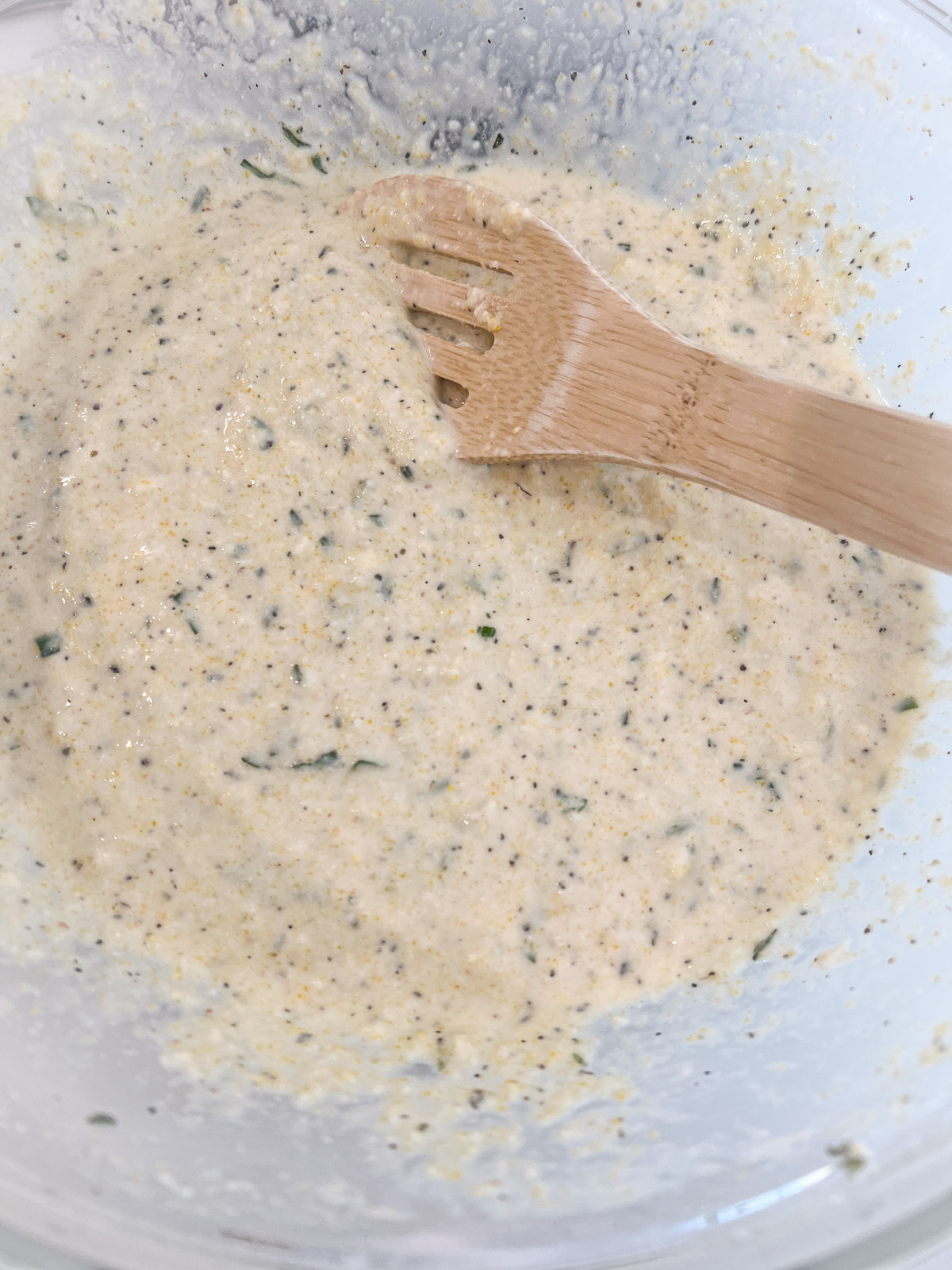 Smooth scarpaccia batter with visible flecks of basil and rosemary