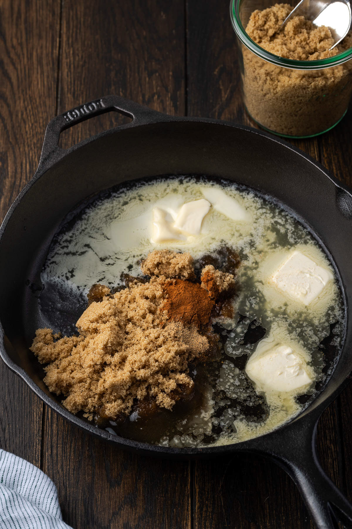 butter brown sugar and cinnamon melting together in a cast iron skillet for cinnamon apples
