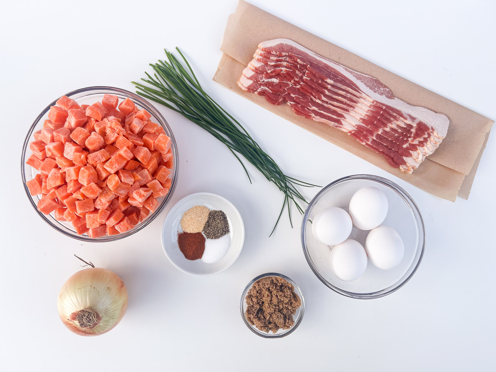 Ingredients for sweet potato hash laid out on a cutting board.