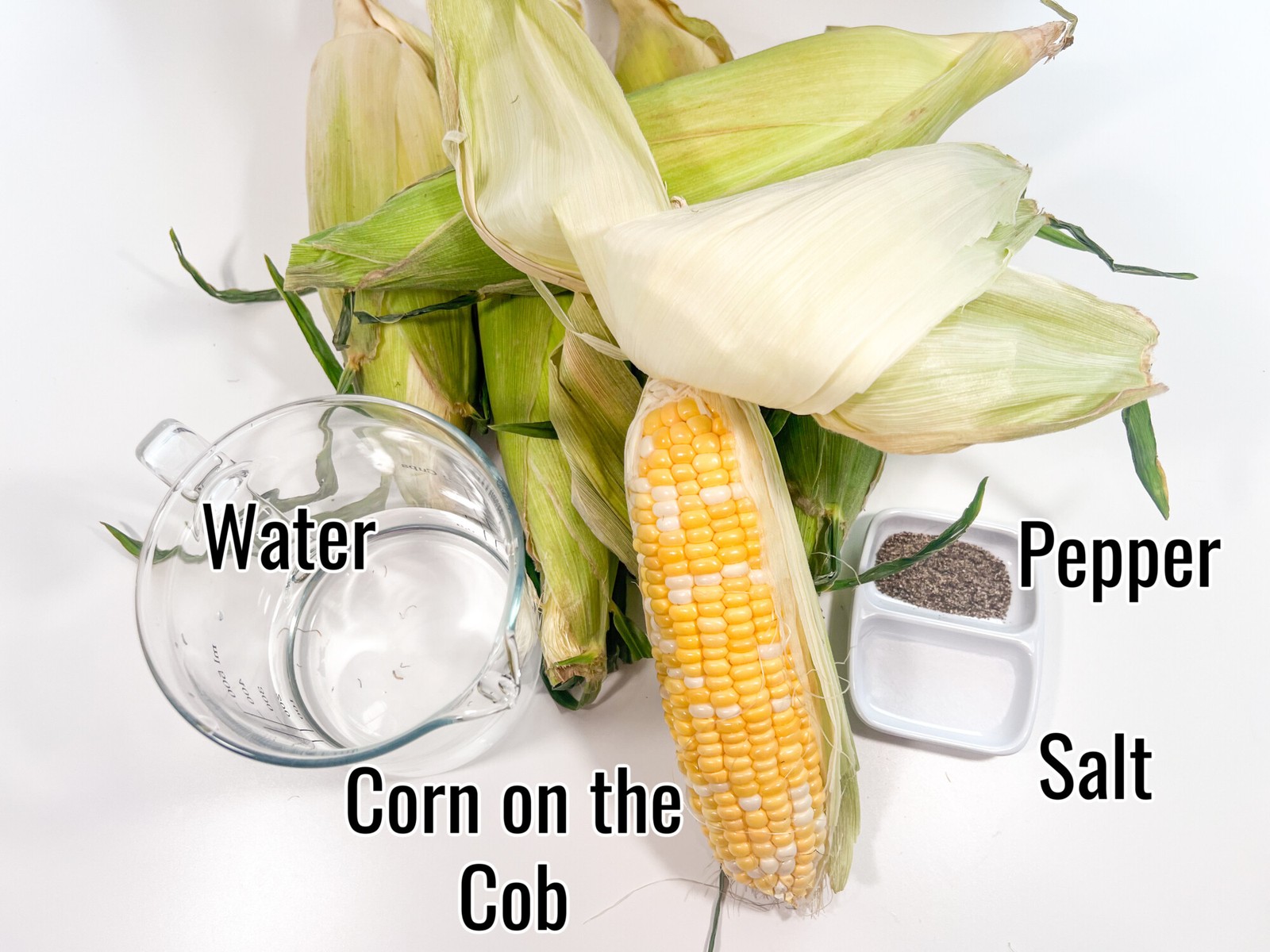 Ingredients needed to make corn on the cob, fresh corn, pepper, salt, and water.