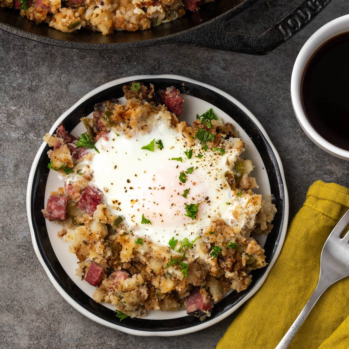Pastrami hash on a plate with a fork to the side. 