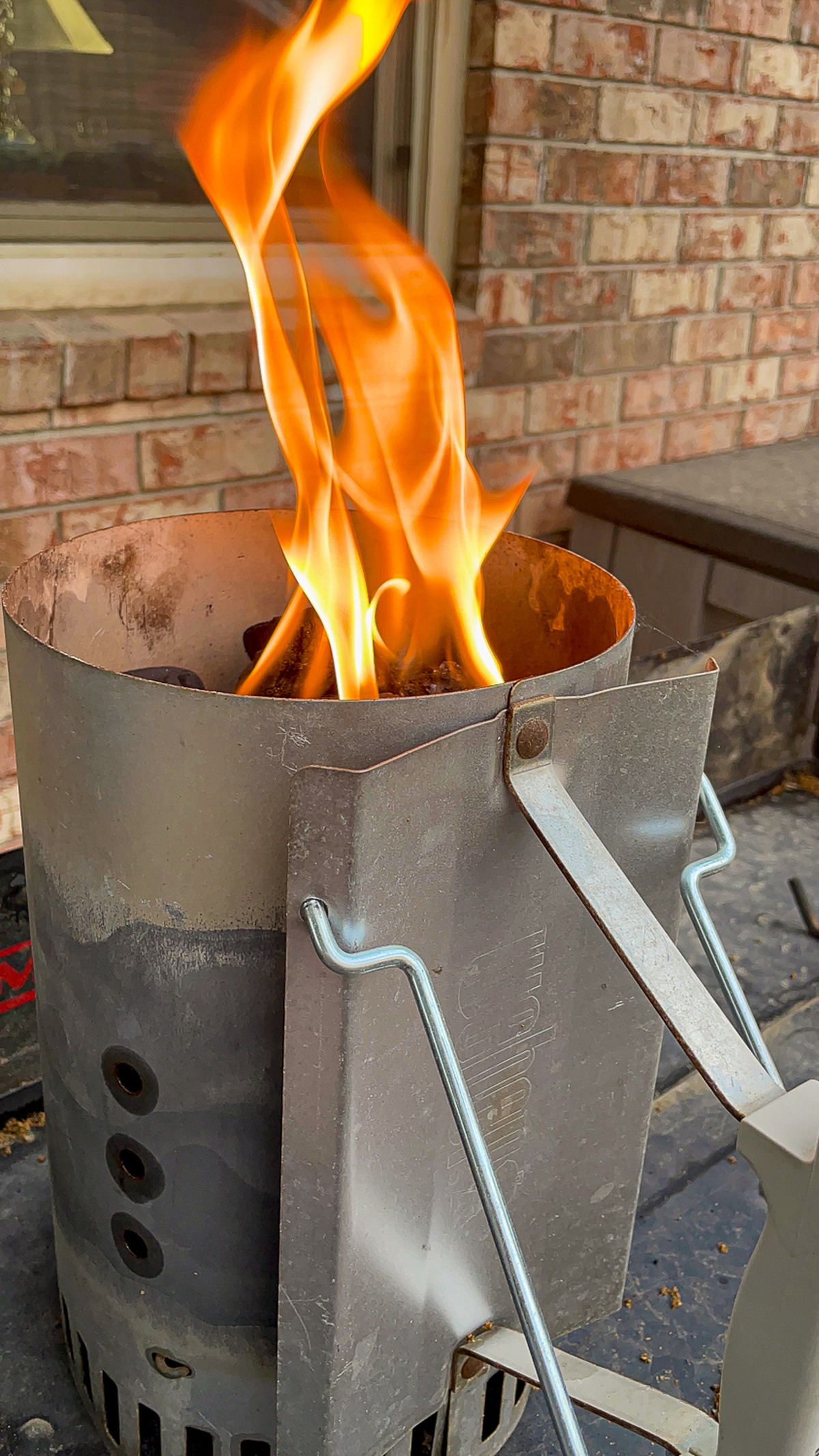 Flames shooting up from a charcoal chimney starter - the right way to prep coals for Dutch oven cooking