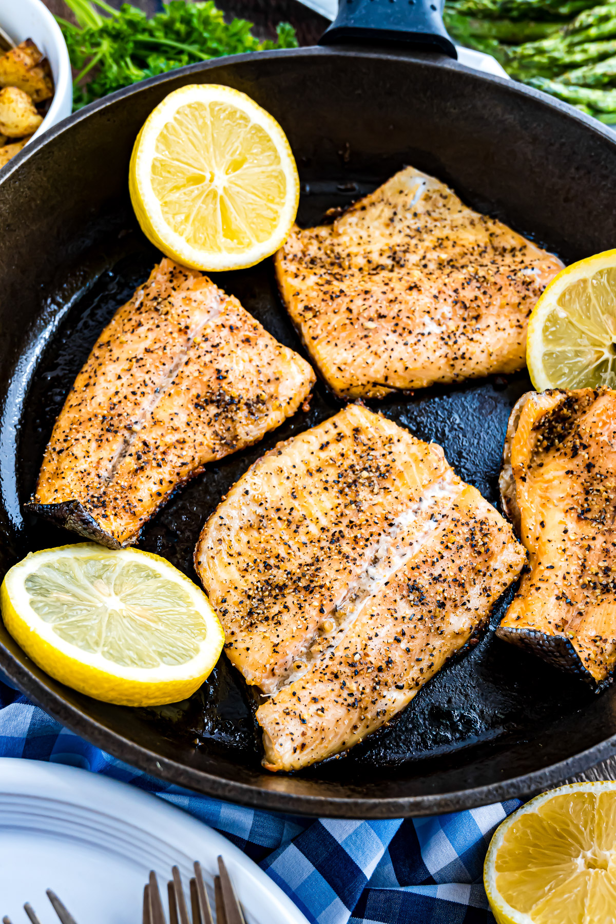 Rainbow trout fillets turning opaque white as they cook in the cast iron skillet