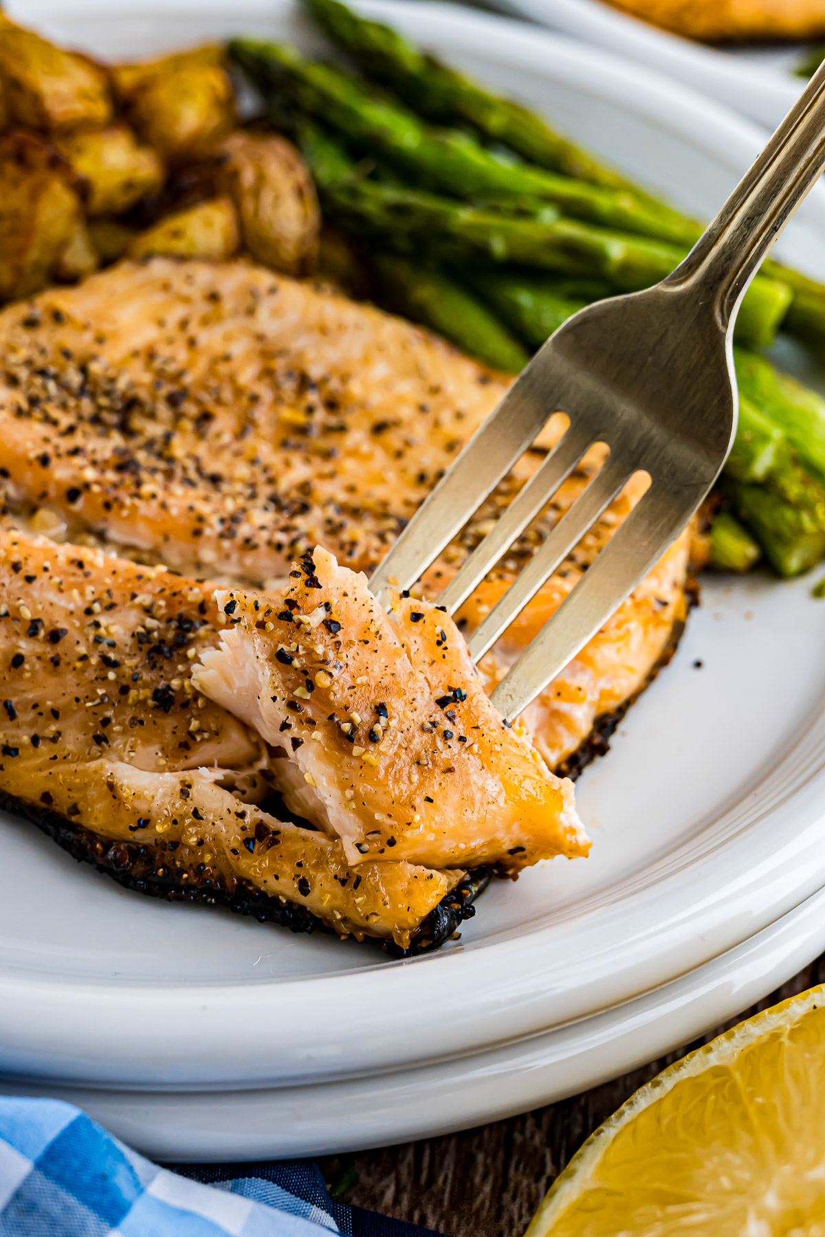 Fork flaking a perfectly cooked grilled rainbow trout fillet showing tender flaky texture