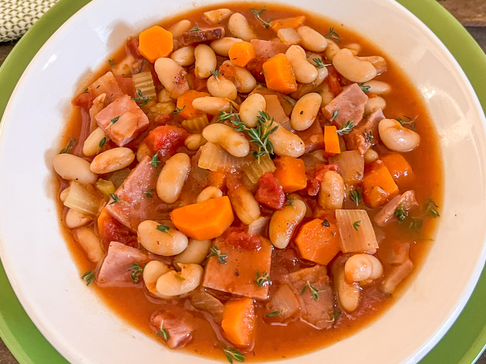 Overhead view of ham and bean soup in a cast iron Dutch oven
