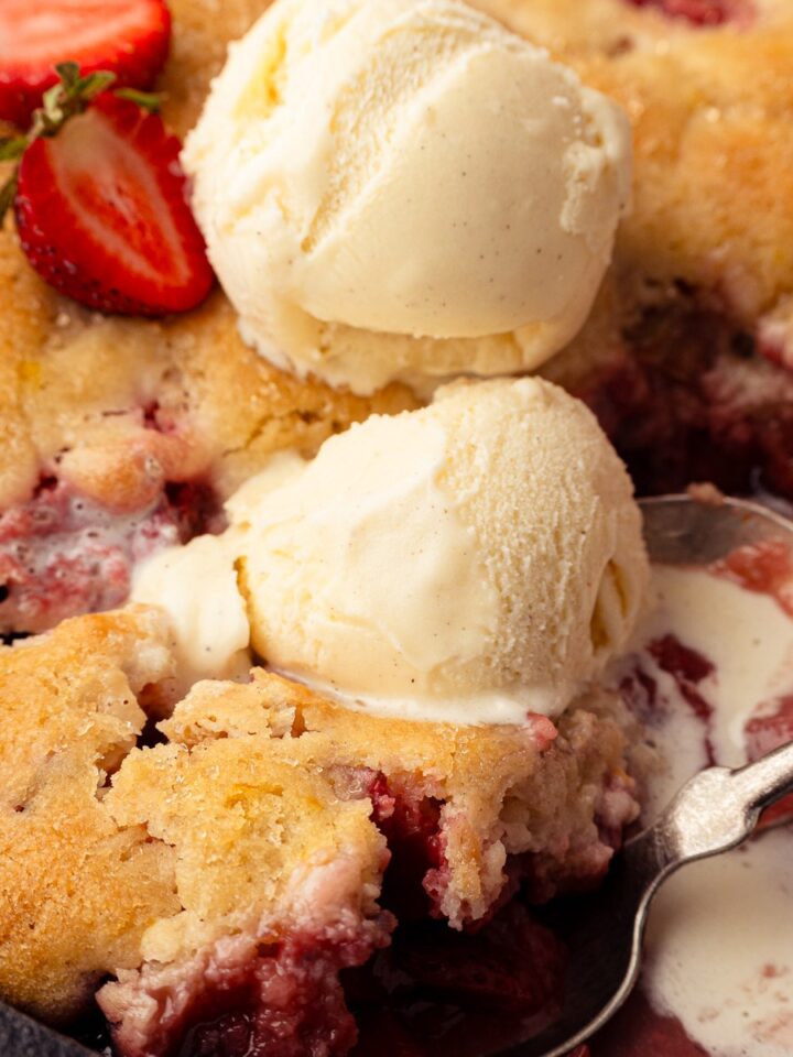 Skillet strawberry rhubarb cobbler with vanilla ice cream in cast iron