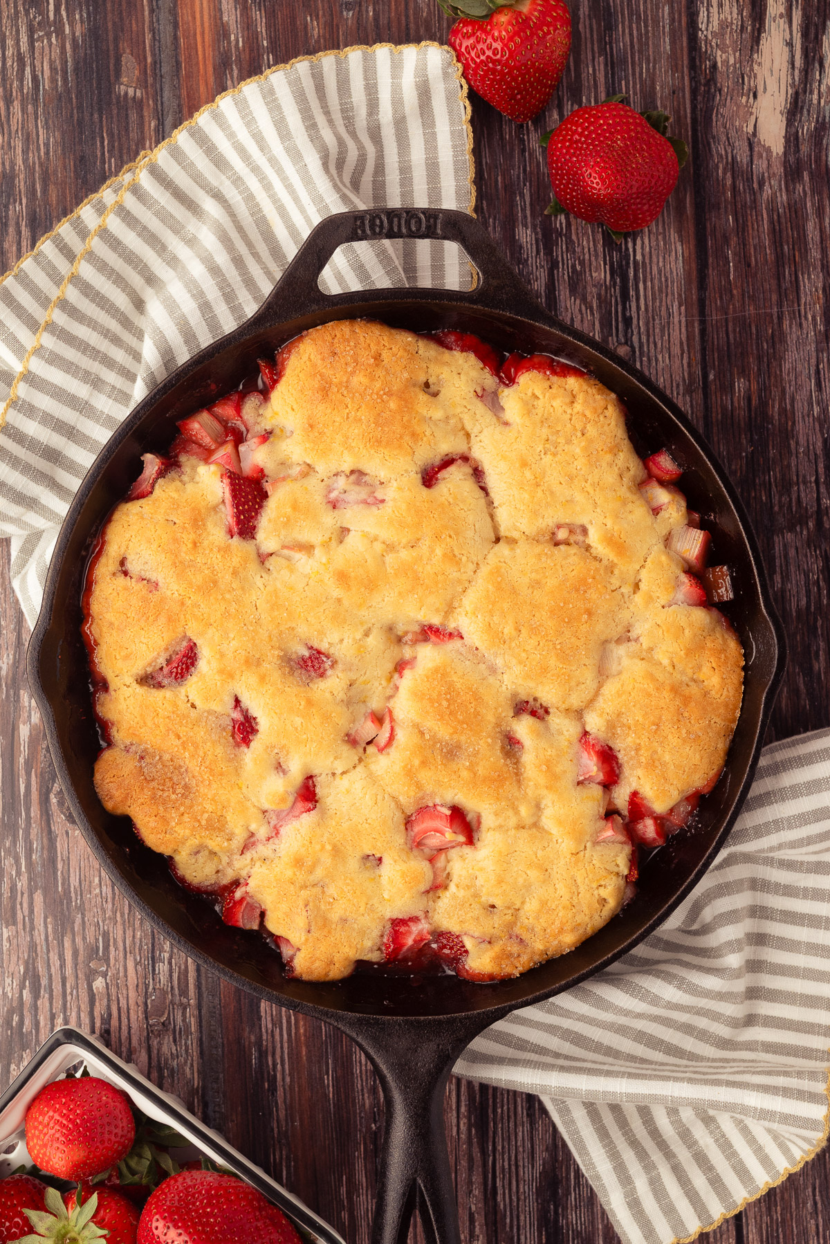 Baked strawberry rhubarb cobbler in a Lodge cast iron skillet