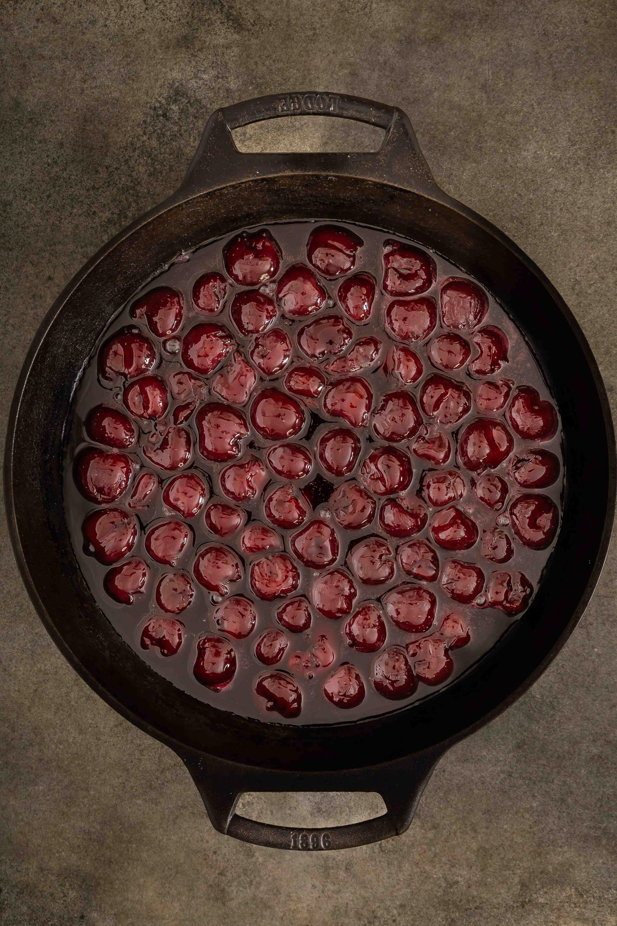 Cherry filling spread evenly in a cast iron skillet