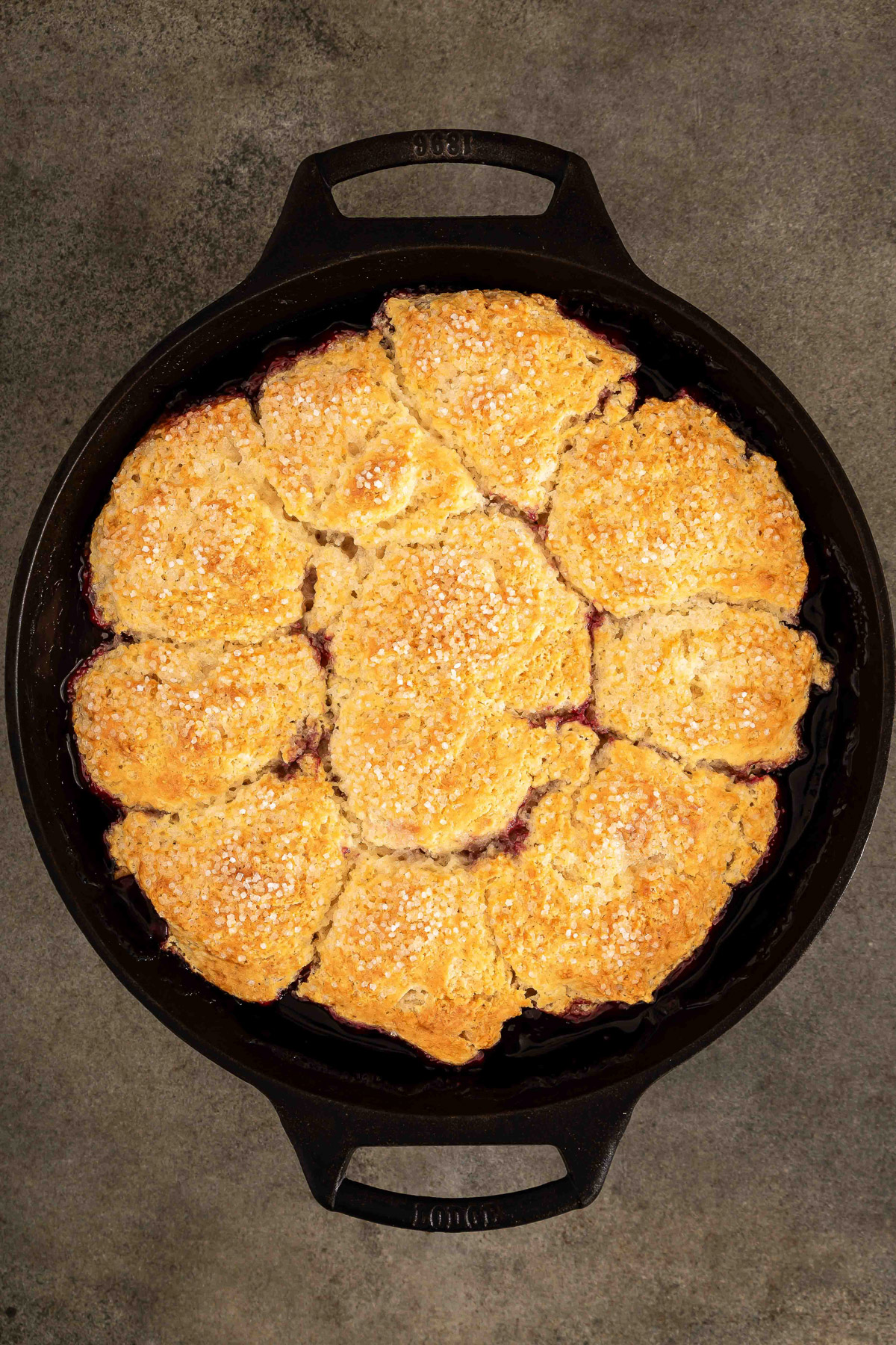 Golden baked cherry cobbler bubbling in a cast iron skillet