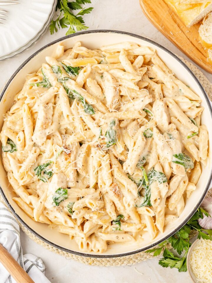 Chicken Florentine pasta in a cast iron skillet topped with fresh parsley
