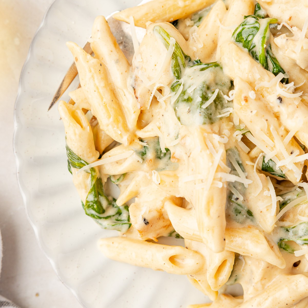 A plate of creamy chicken Florentine pasta with penne and spinach