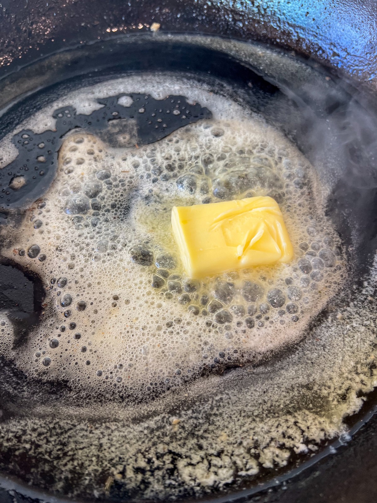 Butter melting in a cast iron skillet.