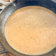 Pan gravy in a cast iron skillet is done and ready to be served.