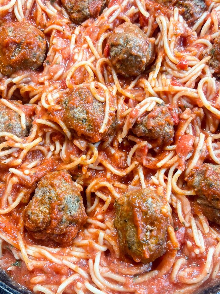 Overhead view of one pot spaghetti and meatballs in a cast iron skillet.