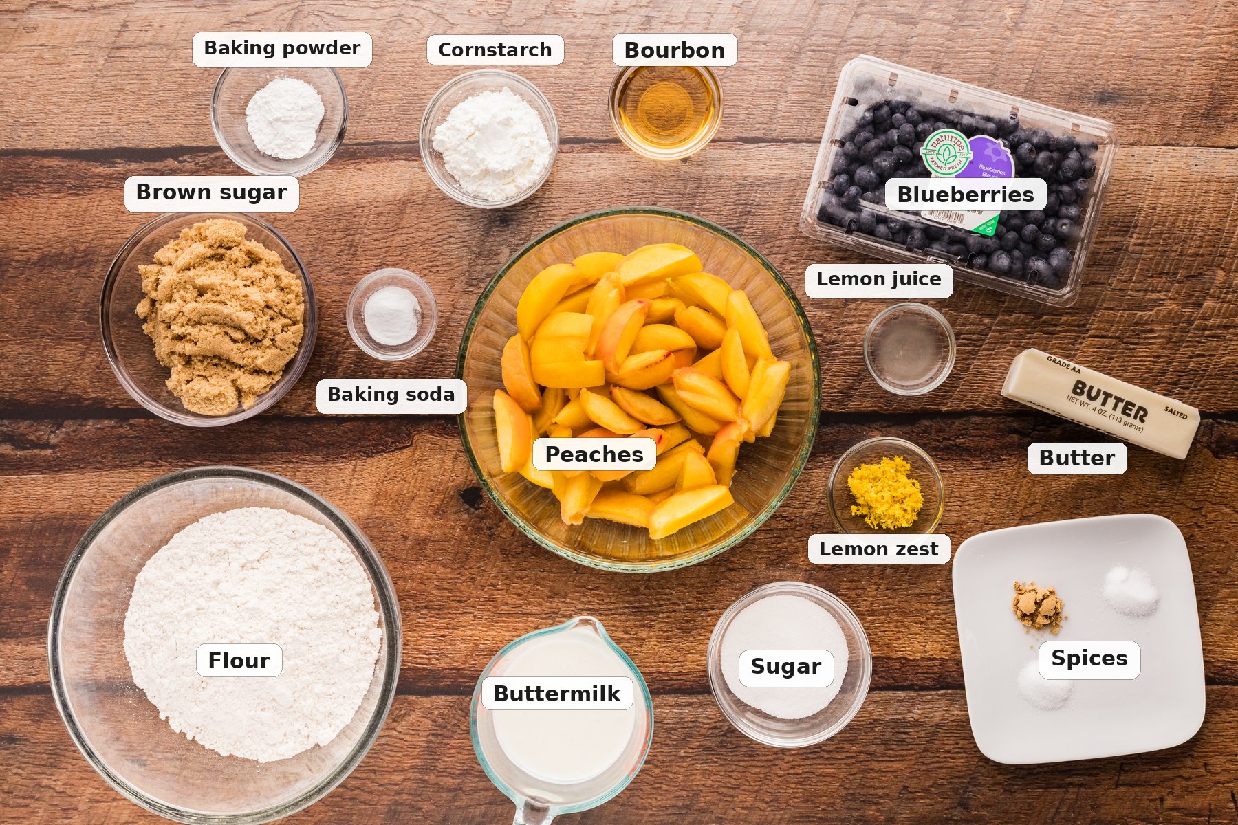 Ingredients for peach blueberry cobbler laid out on a wooden surface