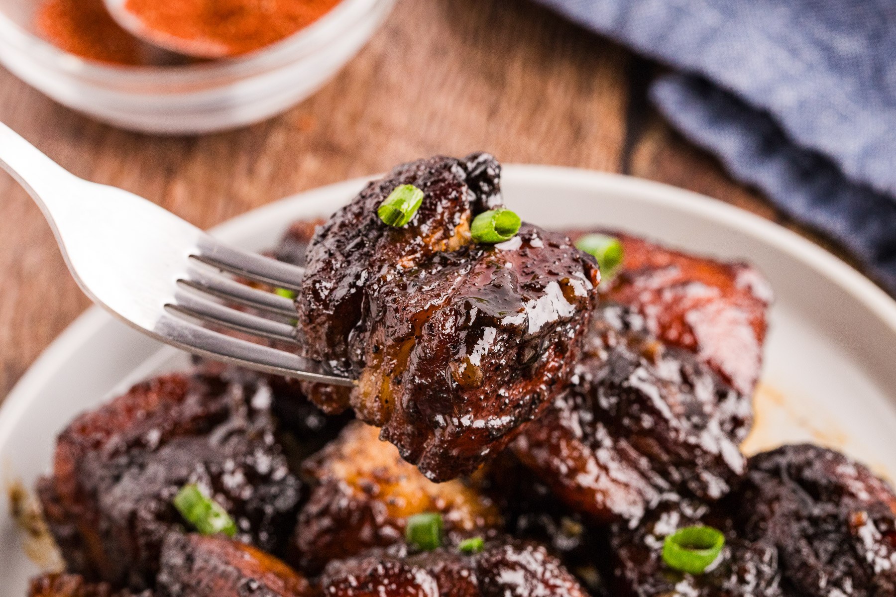 Plated pork belly burnt ends garnished with green onion