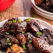 Plated pork belly burnt ends garnished with green onion